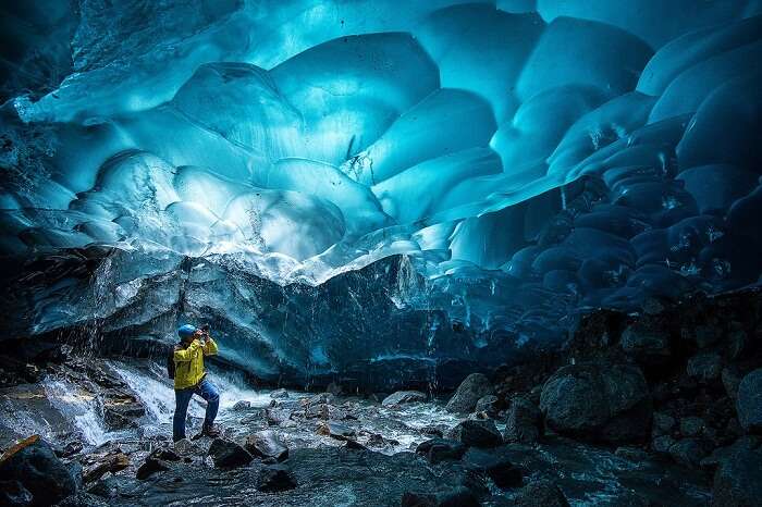 A trekker tries to capture the beauty of the ice caves in his camera