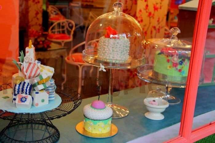 delicious cakes and muffins displayed on the window of Mrs. Magpie bakery