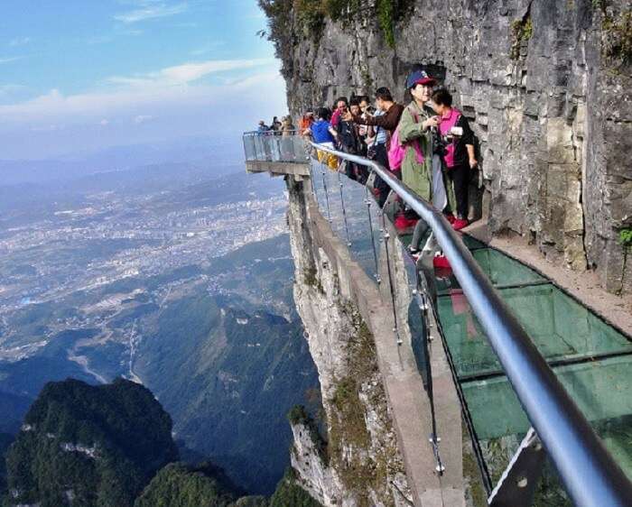 Women dizzying over the glass walkway at Tianmen Mountain Park in China