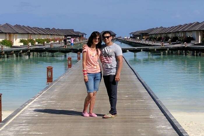 couple pose near water villas