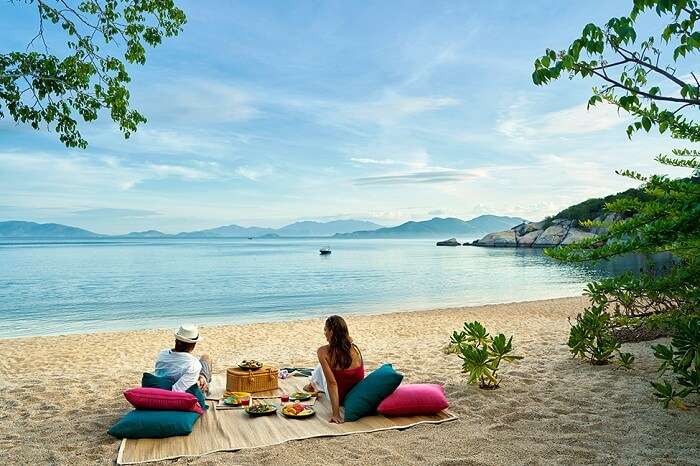 A couple enjoying a beach picnic at Six Senses Ninh Van Bay
