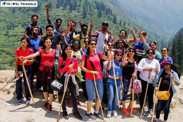 A group of travelers pose after completing a trek in Kasol