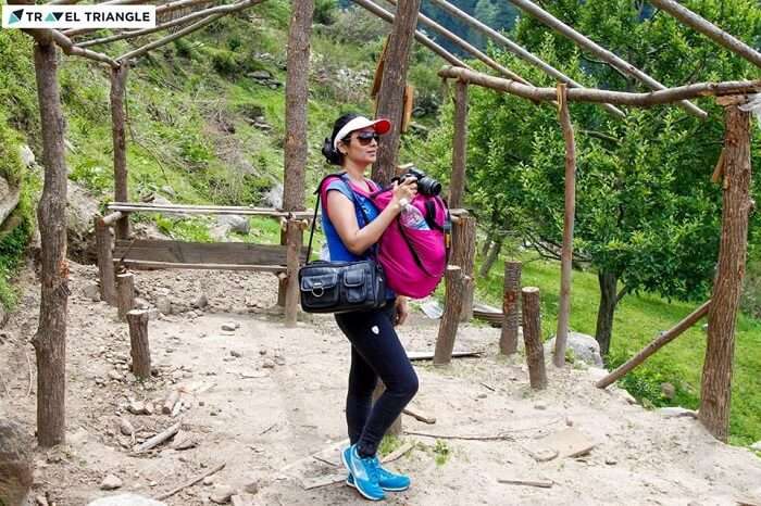 A woman traveler gets ready to capture the beauty of Kasol in her camera