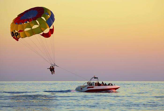 A couple parasailing, a prominent water sport at Alappuzha Beach in Alleppey