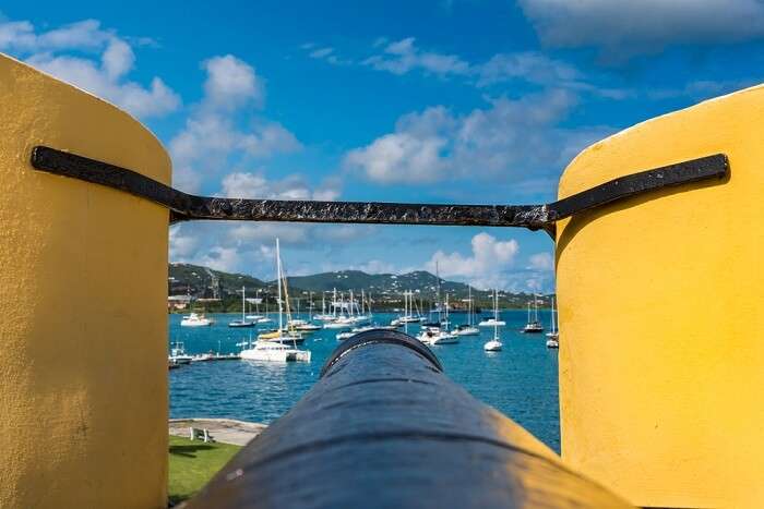 Tip of a vintage cannon through the turret facing the sailboats in the US Virgin Islands