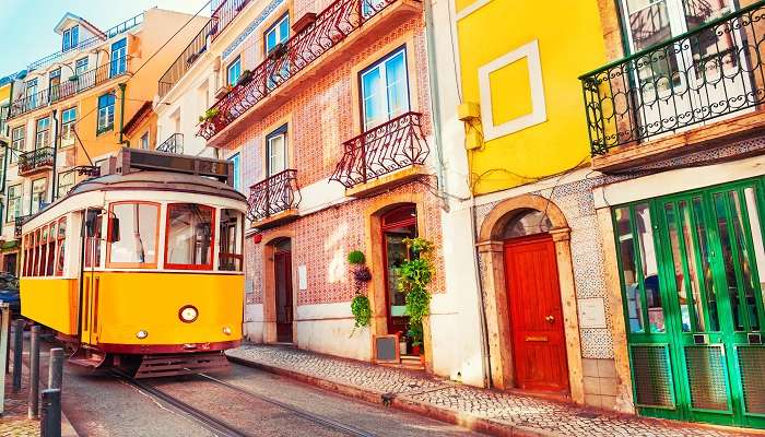 Yellow vintage tram on the street in Lisbon, one of the places to visit in March in world