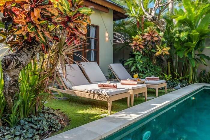 recliners near private pool of luxurious villa essence