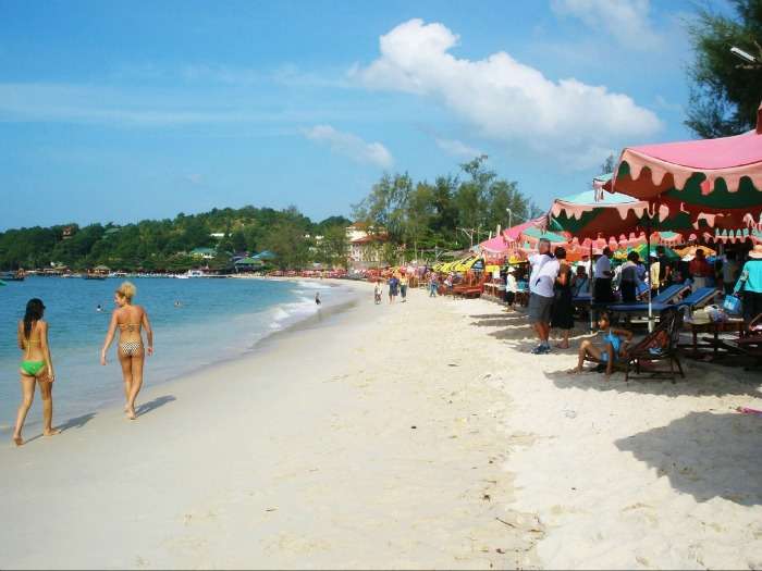 People relaxing under tents at Ochheuteal Beach in sihanoukville, Cambodia