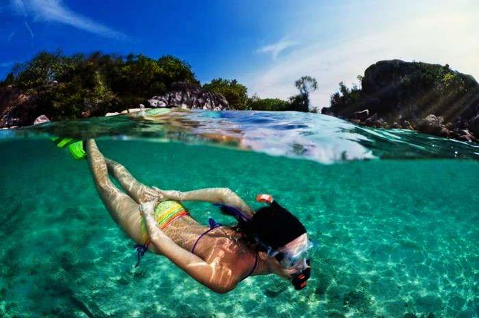 A girl snorkelling in the clean waters of Redang Island in Malaysia