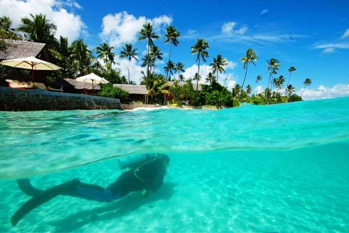 A diver swimming in the clear waters of Wakatobi Beach