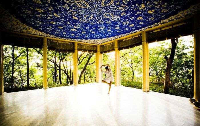 A girl practicing yoga in Ananda in Himalayas one of the luxurious yoga retreats in india