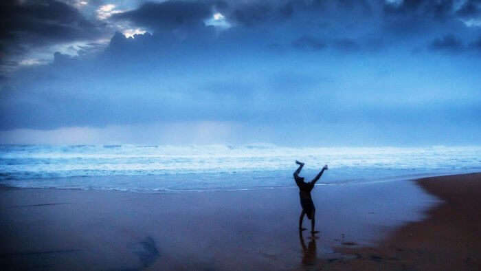 A boy doing a cartwheel at the beach