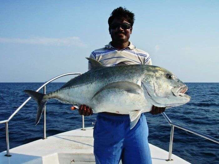 a man catching his prized fish after sport fishing in andaman