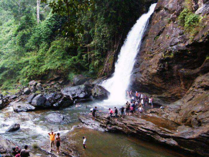 Tourists enjoying at the popular waterfalls of Chethalayam