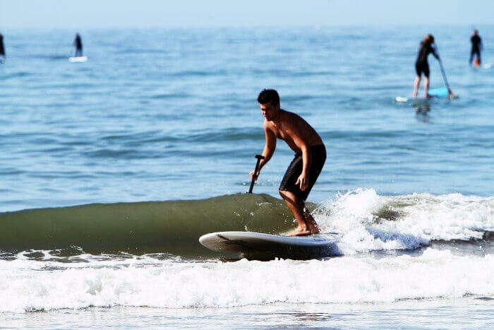 A man indulging in paddleboarding in Goa