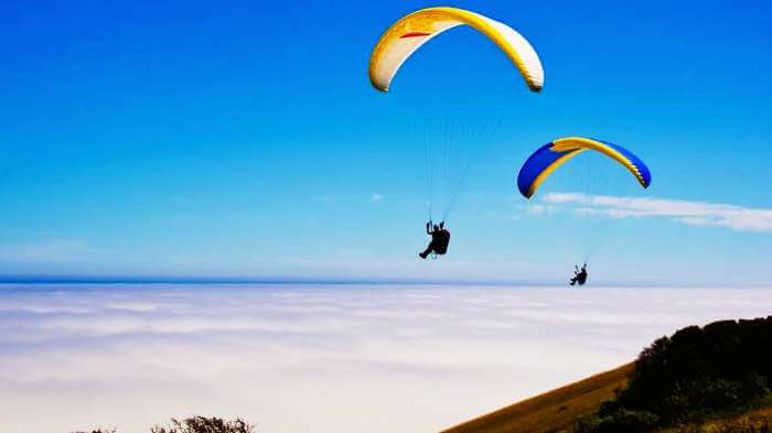 Tourists paragliding at one of the most serene offbeat weekend getaways near Mumbai - Kamshet