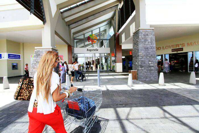 A lady walking with her shopping trolley inside Bagatelle Mall in Moka