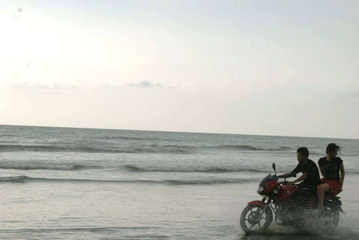 A couple enjoys a bike ride on a lovely evening at the Muzhappilangad Beach