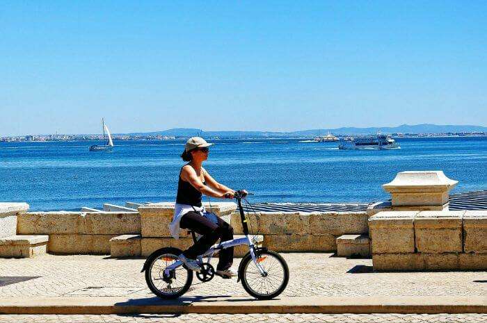 Woman riding a bicycle in Lisbon, Portugal