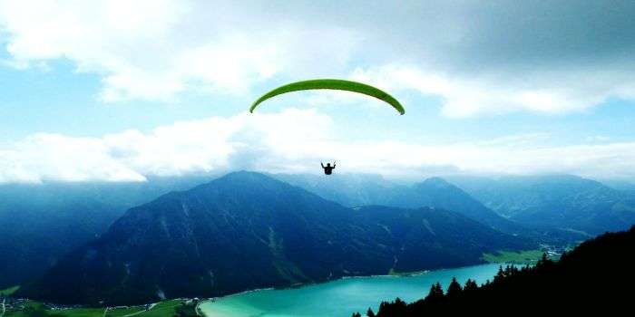 A skydiver glides over the picturesque landscapes as he lands.