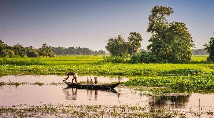 Locals row a boat in the Brahmaputra River to reach the Majuli riverine island
