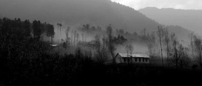 A house between the misty mountains and trees