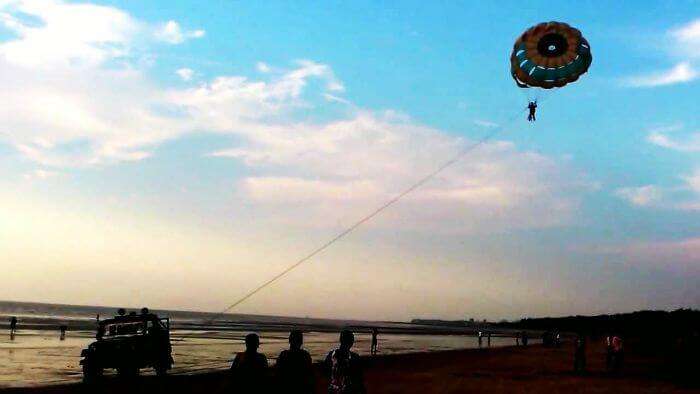 A person enjoys parasailing on a lovely evening at Jampore Beach