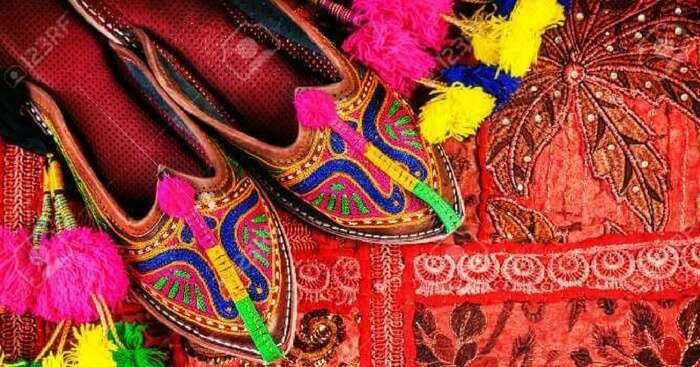 Traditional footwear on display with a colourful background in Jaipur