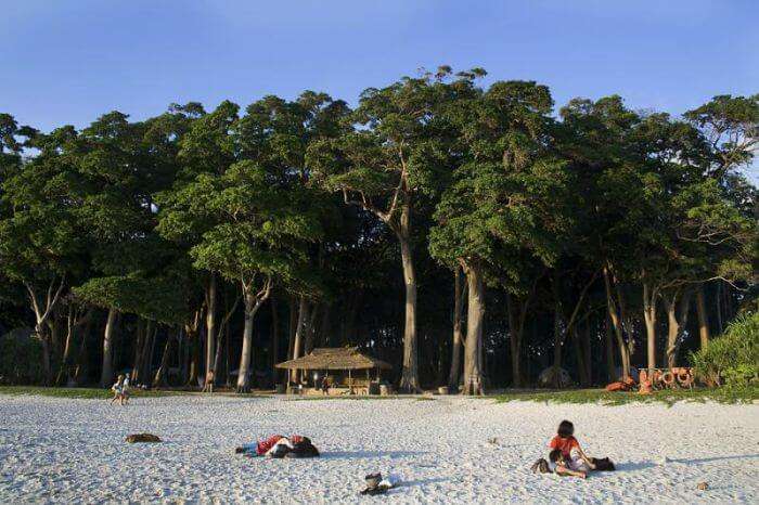 Tourists enjoy the soft white sand of Radhanagar Beach on Havelock Island, Andaman