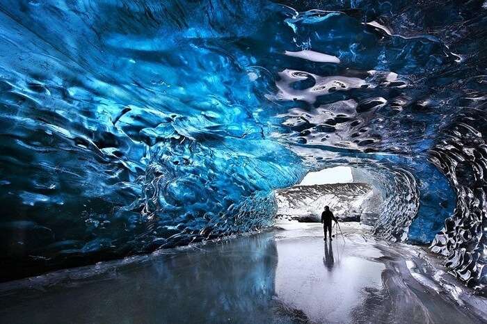 A photographer at the entrance of the icy heaven at Skaftafell in Iceland
