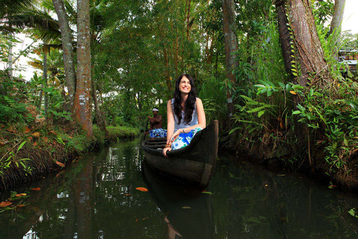 A young woman takes a canoe ride in the backwaters of Alleppey