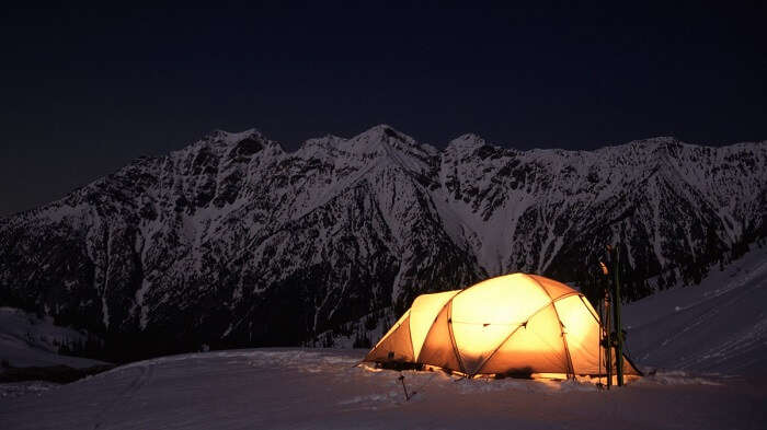 Camping in the snow with the mountains in the background