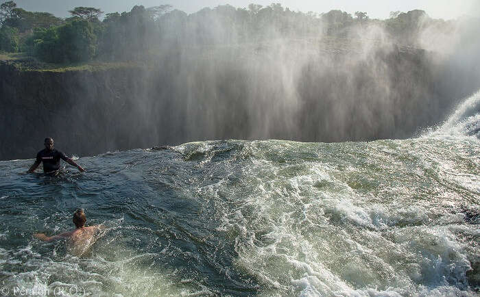 Tourists taking a bath at the Devil Pool at Victoria Falls