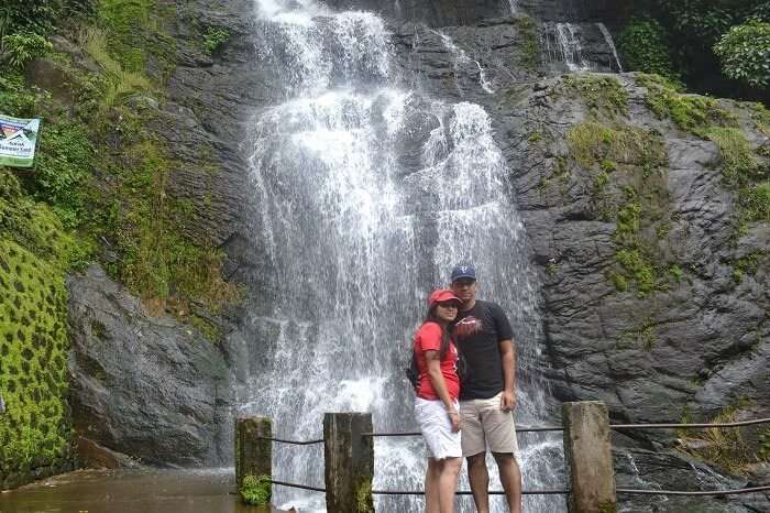 Rajeev and Neha posing in front of the waterfall enroute Alleppey to Thekkady