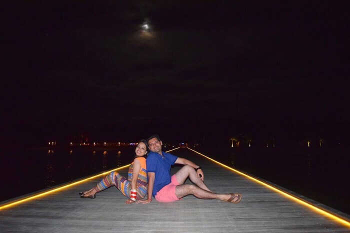 Yatin and wife sitting on the dock in Maldives