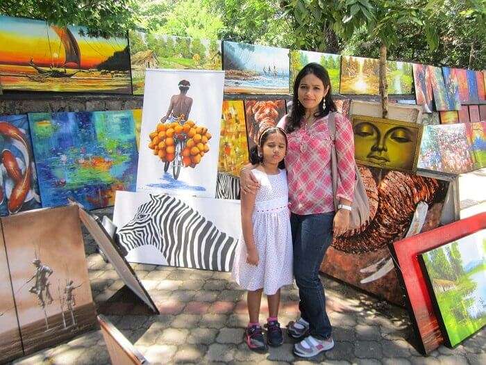 Roshans wife and daughter posing in front of the artist gallery