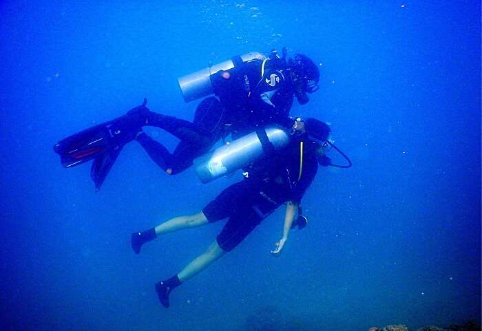 being helped by the professional while scuba diving in andaman