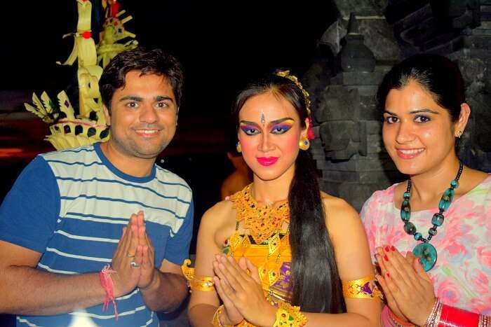 Antriksh and his wife pose with a Kechak dancer in Bali