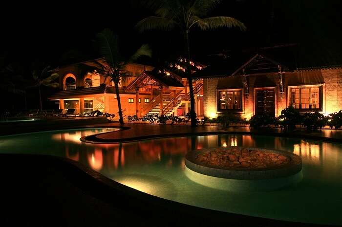 A view of the swimming pool at night at the Lakesong Resort in Kumarakom
