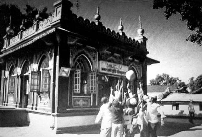 People lifting the levitating stone at Hazrat Qamar Ali Darvesh shrine, Shivapur