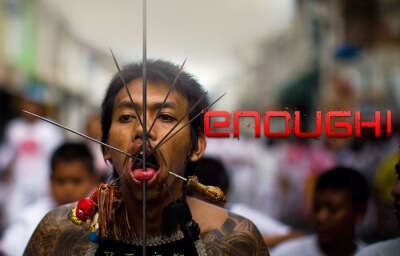 A participant with skewers pierced in his mouth during Vegetarian festival in Thailand