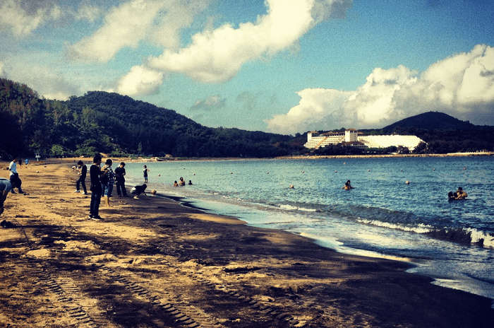 Tourists enjoying at the unique black sand beach of Macau