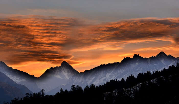 Fiery orange hues of sunrise in the hills of Auli