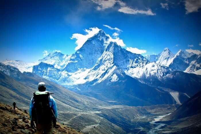 A trekker looks at the majestic Himalayan peaks covered with snow