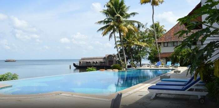 Infinity pool at Lemon Tree Vembanad Lake Resort with a view of the houseboat