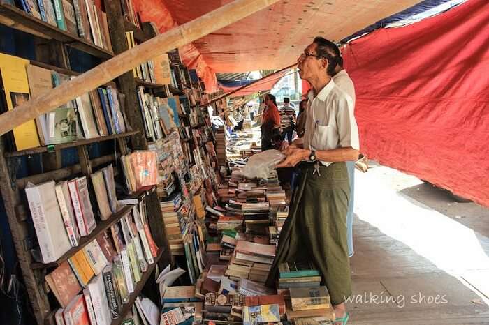 An old looks at the books displayed on the streets of Myanmar