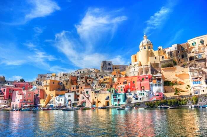 Boats lined up against the shore of the colorful city of Naples