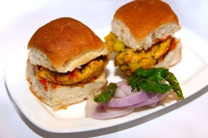 Vada Pav served with onions and green fried chillies