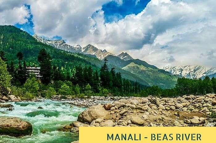 The flowing river Beas at Manali with thee quaint hills in the background