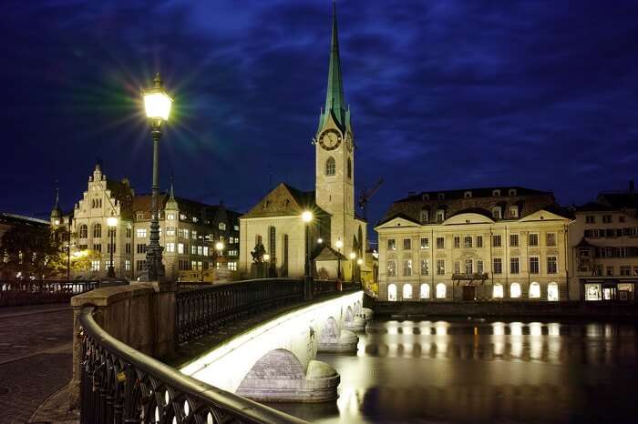 Night photo of Fraumunster Church and bridge over Limmat River